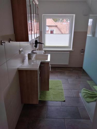 a bathroom with a sink and a window at Ferienhäuser Eggers in Bispingen