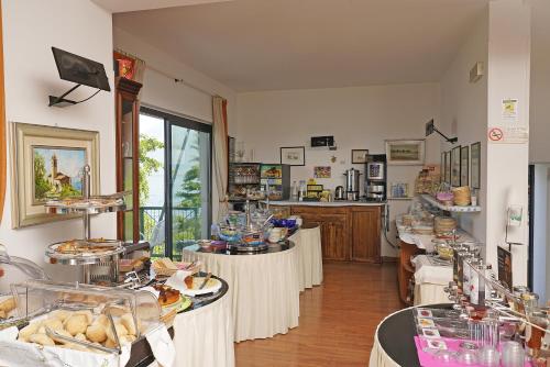 托里德尔贝纳科卡洛塔别墅酒店的房间里有几张桌子，桌子上摆着食物