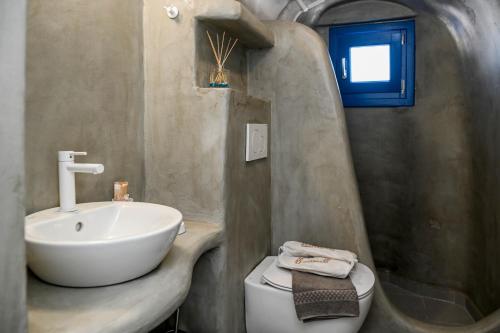a bathroom with a white sink and a toilet at Mary Castelia Villa with Jacuzzi in Akrotiri