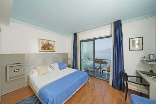 トッリ・デル・ベーナコにあるHotel Villa Carlottaのベッドルーム1室(ベッド1台、大きな窓付)