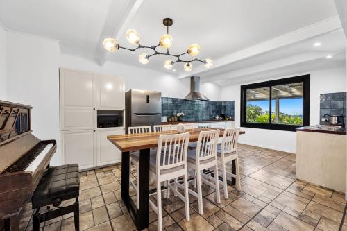 a kitchen with a table and chairs and a piano at Lush rural retreat in Korumburra