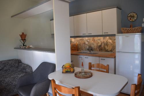 a kitchen with a white table and a white refrigerator at Bellevue Apartments in Sitia