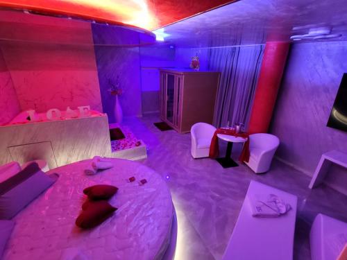 Camera con letto e illuminazione rosa e viola di B&B Luxury Room & SPA a Apricena