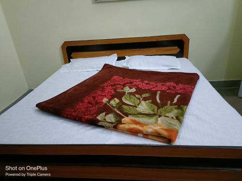 a bed with a blanket on top of it at OYO Home Tawi View Home in Jammu