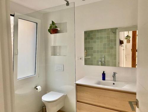 bagno con lavandino, servizi igienici e specchio di MODERNO Y LUMINOSO EN EL CENTRO DE SANTANDER a Santander