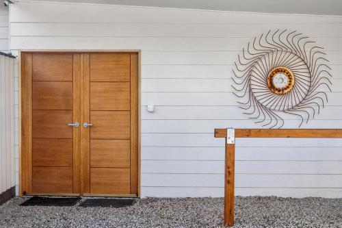 a building with a wooden door and a wreath on the wall at Lush rural retreat in Korumburra