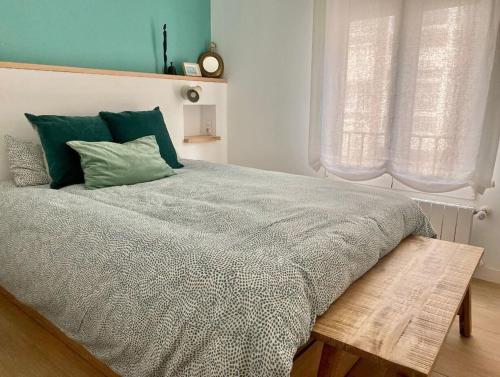 a bedroom with a large bed with green pillows at MODERNO Y LUMINOSO EN EL CENTRO DE SANTANDER in Santander