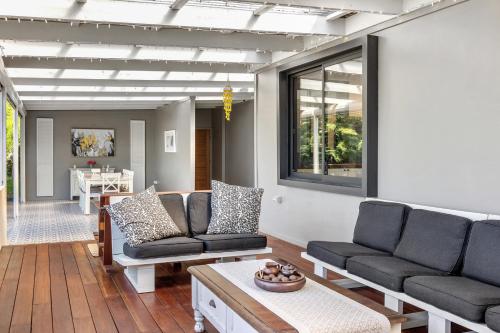 a living room with two couches and a table at Lush rural retreat in Korumburra