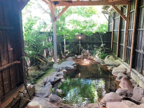 a garden with a pond in the middle of a building at Kurasako Onsen Sakura in Minamioguni