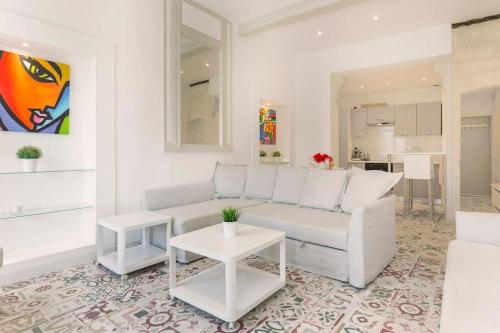 un salon avec un canapé blanc et une table dans l'établissement La Loge de l'Horloge - 1 min PALAIS DES PAPES - AC CLIM - WIFI - HYPERCENTRE - vue sur le carrousel, à Avignon