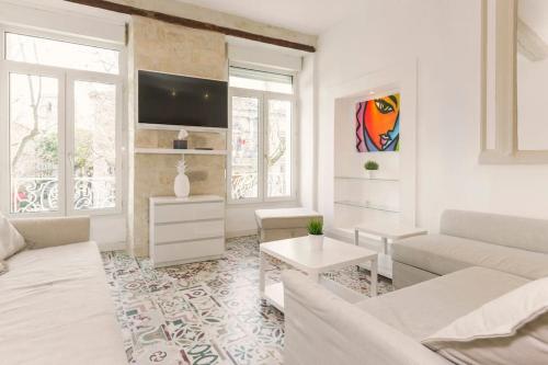 un salon blanc avec un canapé et une table dans l'établissement La Loge de l'Horloge - 1 min PALAIS DES PAPES - AC CLIM - WIFI - HYPERCENTRE - vue sur le carrousel, à Avignon