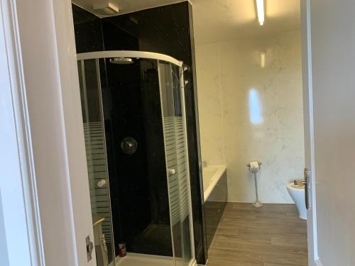 a shower with a glass door in a bathroom at "Room only" at Wetherby Nairn in Nairn