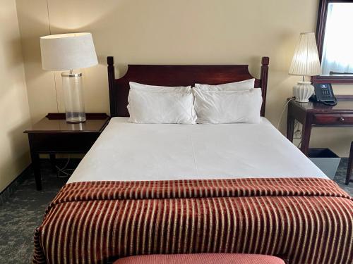 a bedroom with a large bed with two tables and a lamp at The Royal Hotel by Coastlands Hotels & Resorts in Durban
