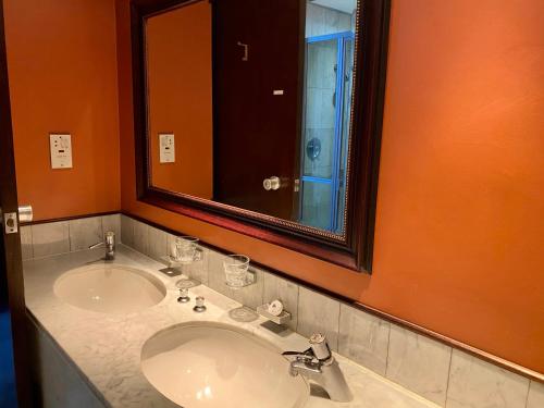 a bathroom with a sink and a large mirror at The Royal Hotel by Coastlands Hotels & Resorts in Durban