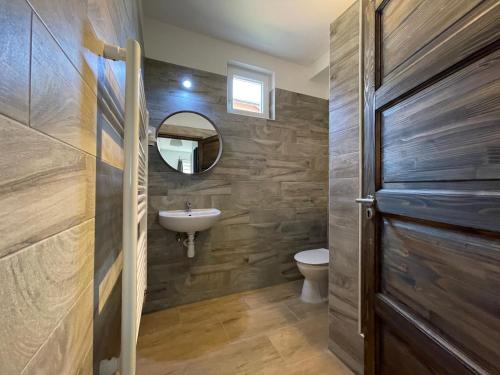 a bathroom with a sink and a toilet and a mirror at New Beachapartman in Siófok