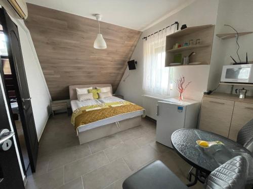 Dormitorio pequeño con cama y mesa en New Beachapartman, en Siófok
