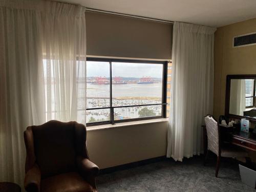 a room with a chair and a window with a view at The Royal Hotel by Coastlands Hotels & Resorts in Durban
