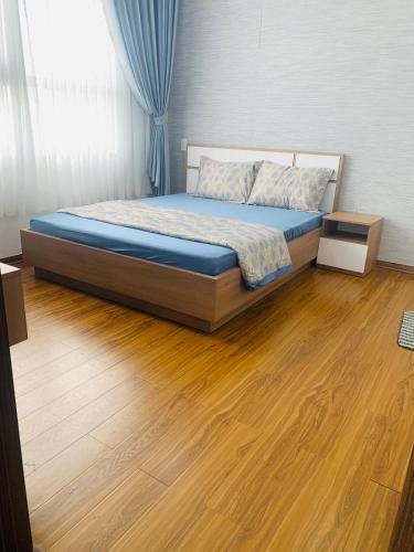 Schlafzimmer mit einem Bett und Holzboden in der Unterkunft Quy nhon Color- Căn hộ du lịch Quy Nhơn 3 in Quy Nhon
