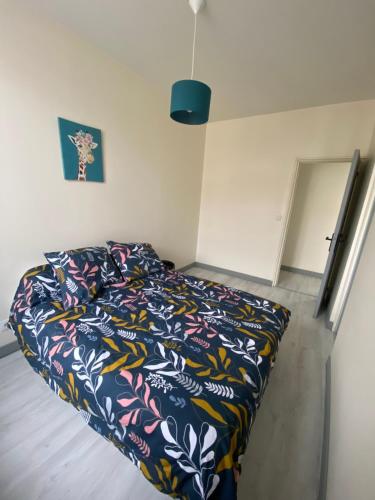 una camera da letto con un letto con un piumone colorato di Le Duplex a Louviers