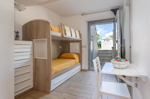 a small bedroom with a bunk bed and a table at ORISTANO CAMERA ARANCIO max 3pers,BAGNO,USO CUCINA in Oristano