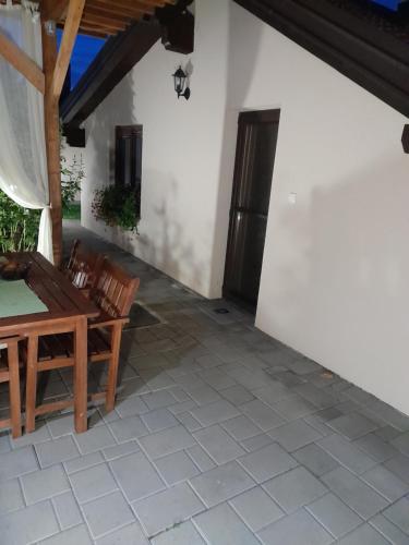 a patio with a table and chairs on a house at Apartman Dujmović 1 in Otočac