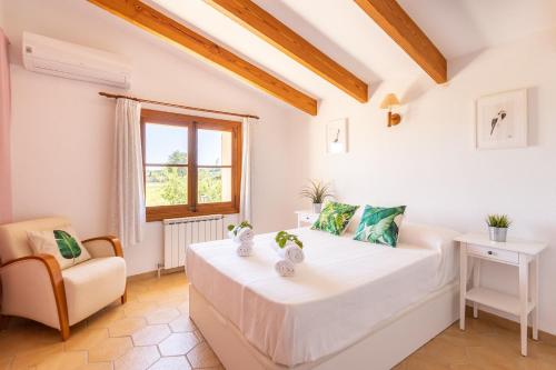 a white room with a bed and a chair at Ideal Property Mallorca - Sa Sinia in Lloret de Vistalegre