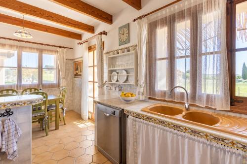 a kitchen with a sink and a counter and windows at Ideal Property Mallorca - Sa Sinia in Lloret de Vistalegre