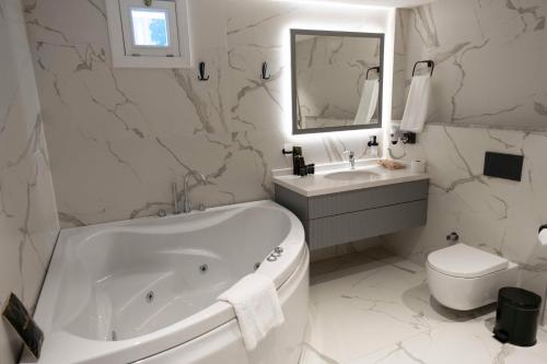 y baño con bañera, aseo y lavamanos. en Royal Hayat Hotel Old Town en Antalya
