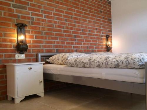 1 dormitorio con cama y pared de ladrillo en Ferienwohnung Abendsonne, 