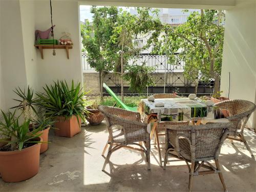 um pátio com uma mesa, cadeiras e plantas em Villa Malena Volos Alykes Beach em Dhimínion