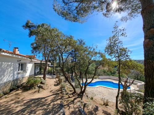 a villa with a swimming pool and trees at Chalet con piscina en Torrelodones in Torrelodones