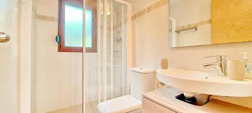 een witte badkamer met een wastafel en een douche bij Jardines de Montemar IV in Benissa