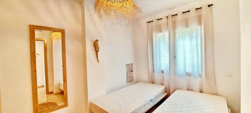 een spiegel en een bank in een kamer met een raam bij Jardines de Montemar IV in Benissa