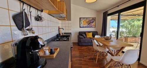 a kitchen and living room with a stove and a table at PetraSicula Apartment in Acitrezza