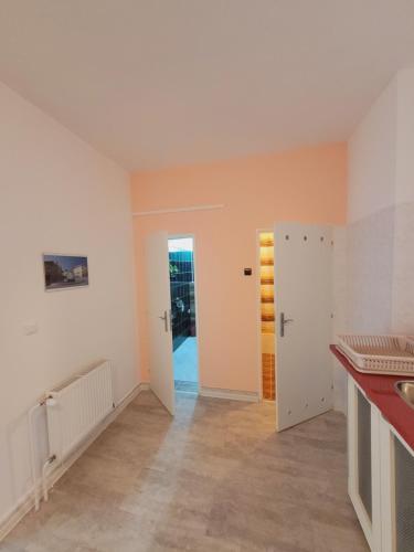 a kitchen with white walls and an open door at Apartmány Brno in Brno