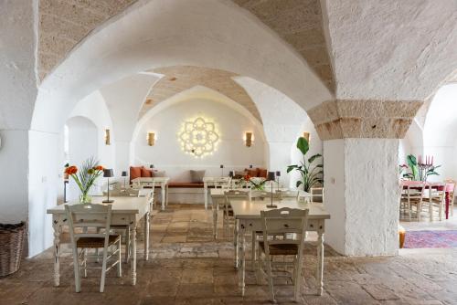 uma sala de jantar com mesas e cadeiras num edifício em Masseria Borgo San Marco em Fasano