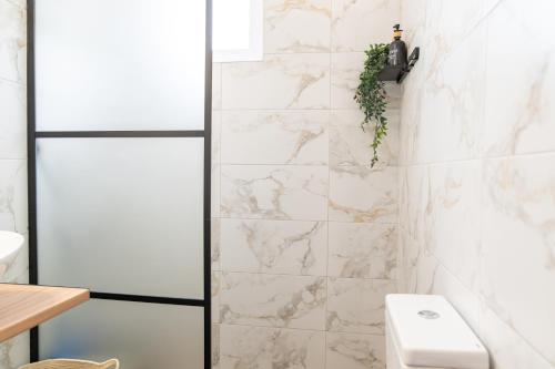 uma casa de banho com azulejos de mármore branco e um chuveiro em White Dream House em Cidade de Kos