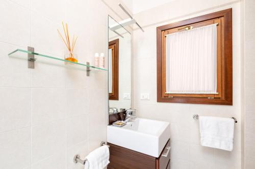 a white bathroom with a sink and a mirror at Residence Ca' Foscolo in Venice