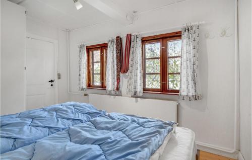 um quarto com uma cama azul e 2 janelas em 1 Bedroom Pet Friendly Home In Svendborg em Svendborg