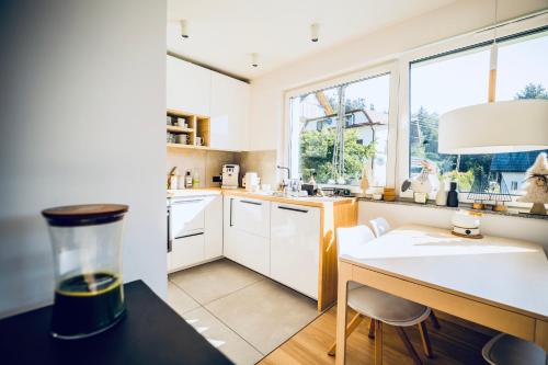a kitchen with white cabinets and a desk and a window at Widokowy apartament Jodłowa Ski&Bike in Szczyrk