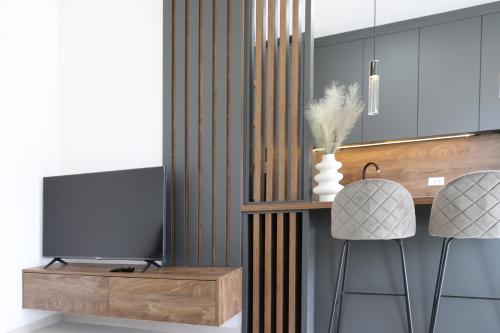 a kitchen with two stools and a television at Brand new apartment with private pool in Njivice