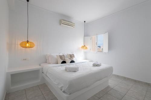a white bedroom with a bed and a bath tub at BlackRock suites in Karterados