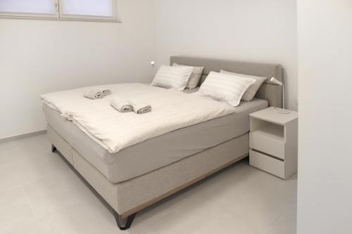a bed with two wedding rings on top of it at Brand new apartment with private pool in Njivice