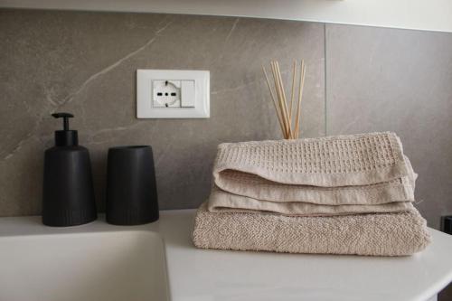 un mucchio di asciugamani seduti sopra un bancone del bagno di Elina Apartment a Merano
