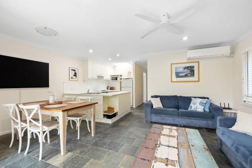 a living room with a blue couch and a table at 1 36 Alderly Tce Little Cove in Noosa Heads