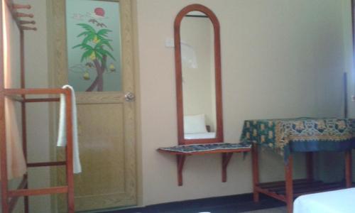a room with a mirror and a chair next to a door at Moon Light Rest in Galle