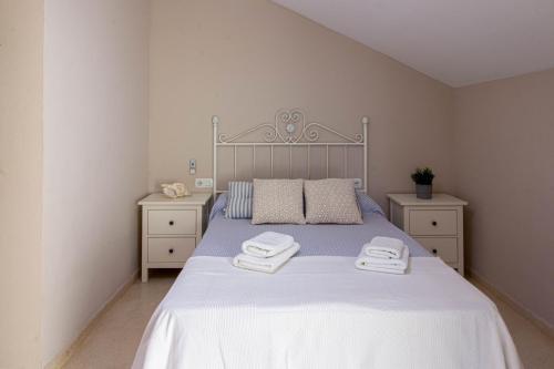 1 dormitorio con 1 cama con 2 toallas en A view of the beach duplex, en Málaga