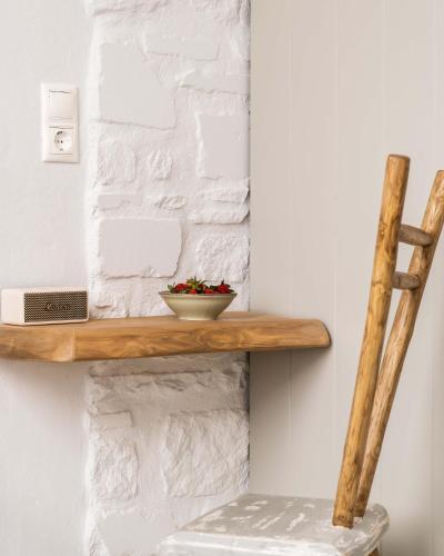 a wooden shelf on a wall with a plant on it at Cavos Paros Boho Chic sea-view apartment in Aliki, Paros in Aliki