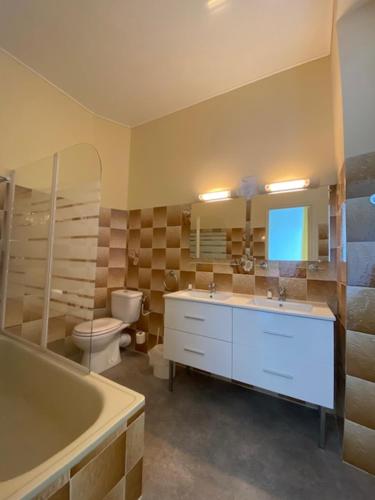 a bathroom with a tub and a toilet and a sink at HOTEL ST SEBASTIEN in Roquebillière