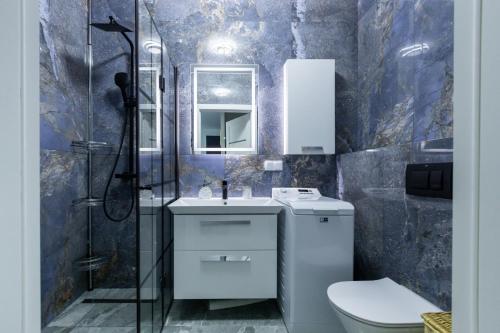 een badkamer met een toilet, een wastafel en een douche bij Red Bridge Apartament in Dziwnów